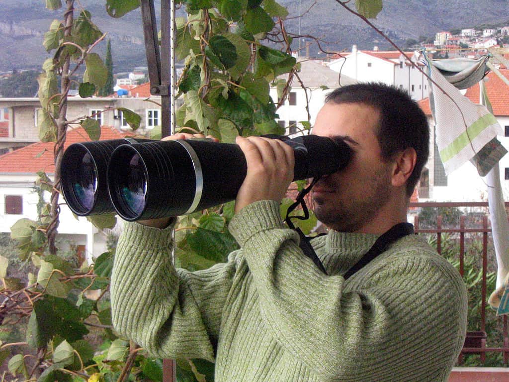 giant binoculars man holding giant binoculars 